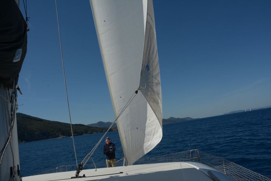Skipper on the foredeck checking the sail offshore