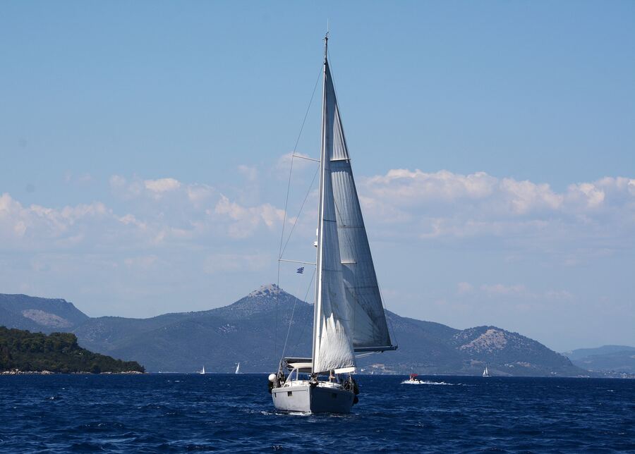 Sailboat under sail on open water, far from the coast