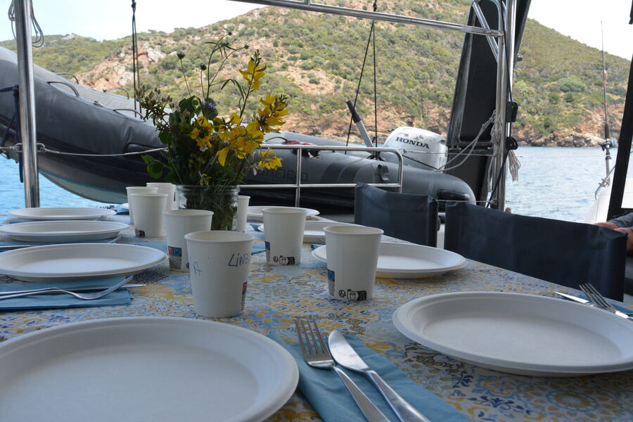 Table set for a meal aboard a boat at a calm anchorage